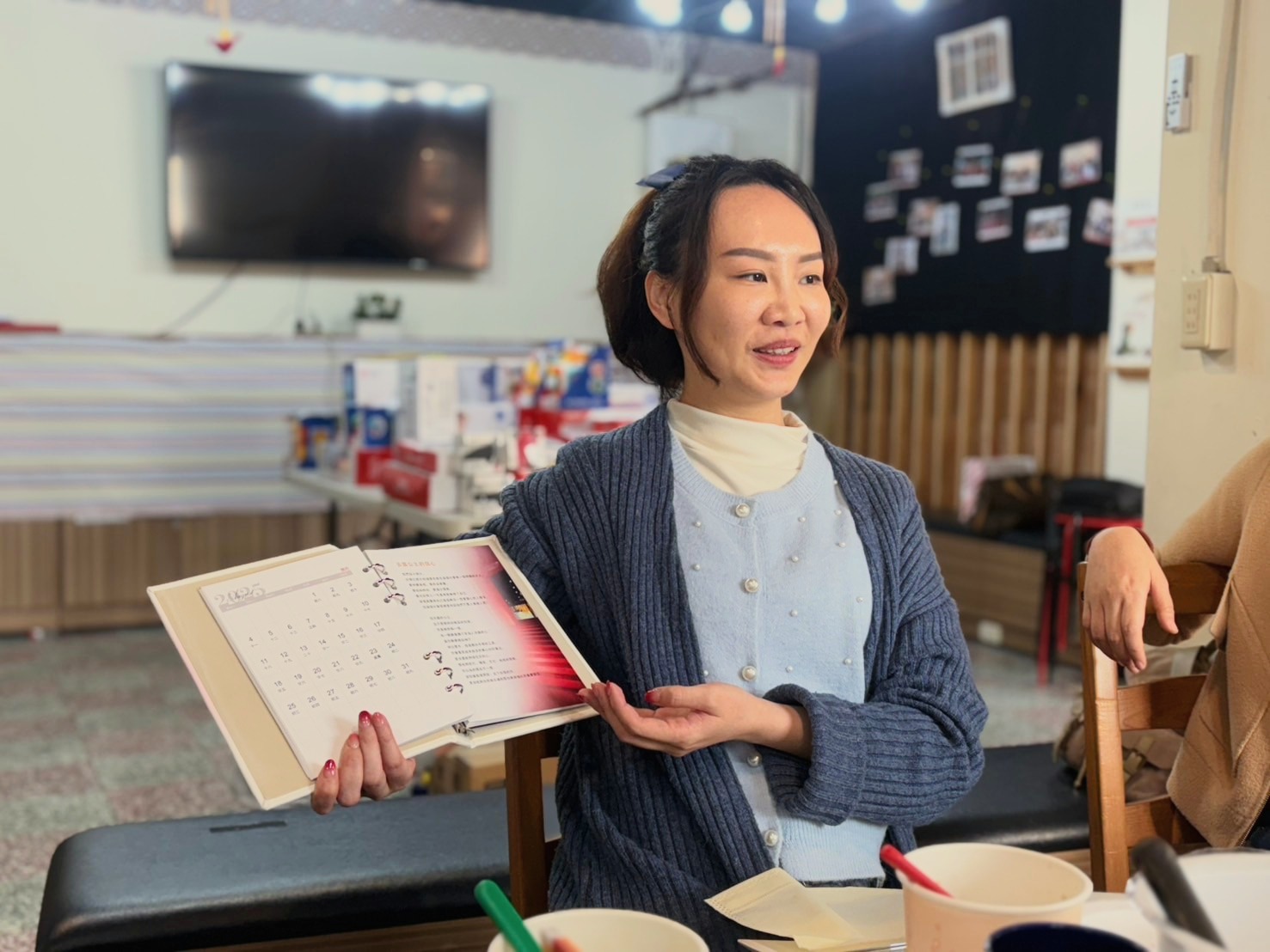 Tina 拿著日茶見喜的印刷內容說明給合作方